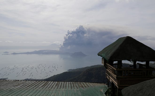 Taal volcano continues to erupt in Lemery, Batangas, southern Philippines on Monday, Jan. 13, 2020. Red-hot lava gushed out of a volcano near the Philippine capital on Monday, as thousands of people fled the area through heavy ash. Experts warned that the eruption could get worse and plans were being made to evacuate hundreds of thousands. (AP Photo/Aaron Favila)