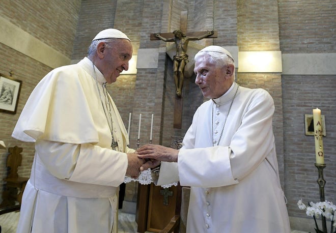 In this June 28, 2017, file photo, Pope Francis, left, and Pope Benedict XVI, meet each other on the occasion of the elevation of five new cardinals at the Vatican. Retired Pope Benedict XVI has broken his silence to reaffirm the value of priestly celibacy, co-authoring a bombshell book at the precise moment that Pope Francis is weighing whether to allow married men to be ordained to address the Catholic priest shortage. [L’OSSERVATORE ROMANO/POOL PHOTO VIA ASSOCIATED PRESS]