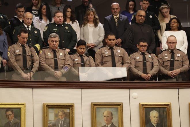 Members of the Florida Highway Patrol stand and bow their heads during a moment of silence held in remembrance of the victims of the December shooting at NAS Pensacola in the Senate chamber Tuesday, Jan. 14, 2020. [Photo by Tori Lynn Schneider/Tallahassee Democrat]