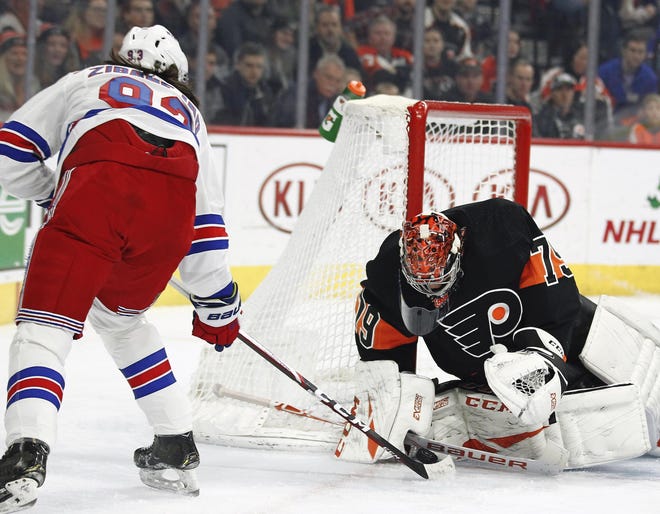 Flyers goalie Carter Hart makes the save on the Rangers' Mika Zibanejad. [TOM MIHALEK / ASSOCIATED PRESS]
