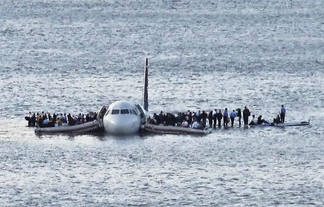 Airline passengers wait to be rescued on the wings of a US Airways Airbus 320 jetliner that safely ditched by Capt. Chesley "Sully" Sullenberger in the frigid waters of the Hudson River in New York, after a flock of birds knocked out both its engines. [Steven Day/The Associated Press]