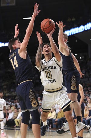 Georgia Tech guard Michael Devoe is double teamed by Notre Dame defenders Nate Laszewski (left) and Rex Pflueger (right) as he goes to the basket Wednesday Atlanta. [Curtis Compton/Atlanta Journal Constitution via AP]