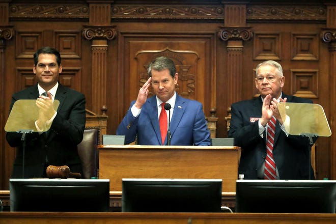 Gov. Brian Kemp, center, is flanked by House Speaker David Ralston, R-Blue Ridge, right, and Lt. Gov. Geoff Duncan as he salutes former U.S. Senator Johnny Isakson, R-Ga., during the State of the State address before a joint session of the Georgia General Assembly Thursday, Jan. 16, 2020, in Atlanta.[AP Photo/John Bazemore]