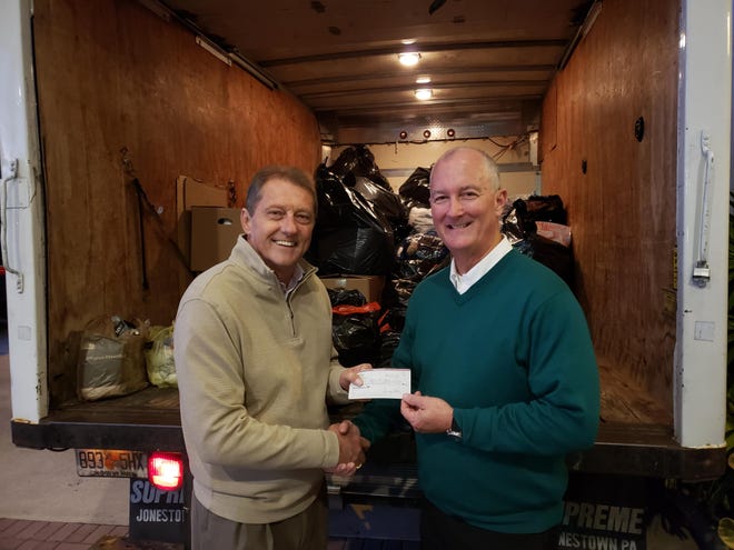 Greg Foster, Building Association Managers of Volusia board president, presents Buck James, Halifax Urban Ministries executive director, with a check for $1,100. (Photo provided)