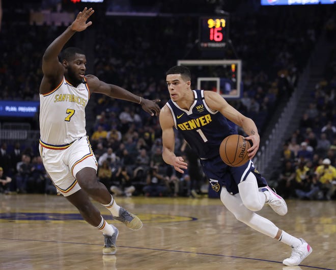 Denver Nuggets' Michael Porter Jr., right, drives the ball against Golden State Warriors' Eric Paschall (7) during the first half of a game Thursday in San Francisco. [Ben Margot/The Associated Press]