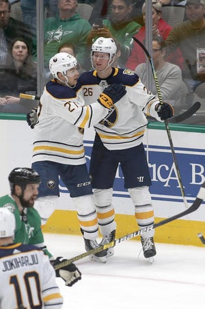 Buffalo Sabres defenseman Rasmus Dahlin, right, is congratulated by center Curtis Lazar, left, after scoring a goal against the Dallas Stars during the second period of an NHL hockey game in Dallas, Thursday, Jan. 16, 2020. (AP Photo/Ray Carlin)