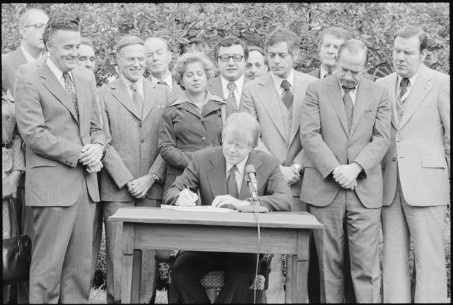 President Jimmy Carter signs the Housing and Community Development Act of 1977, which contained the Community Reinvestment Act.