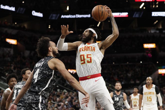 Atlanta Hawks guard DeAndre' Bembry (95) drives to the basket against San Antonio Spurs guard Derrick White (4) during the first half in San Antonio on Friday night. [ERIC GAY/THE ASSOCIATED PRESS]