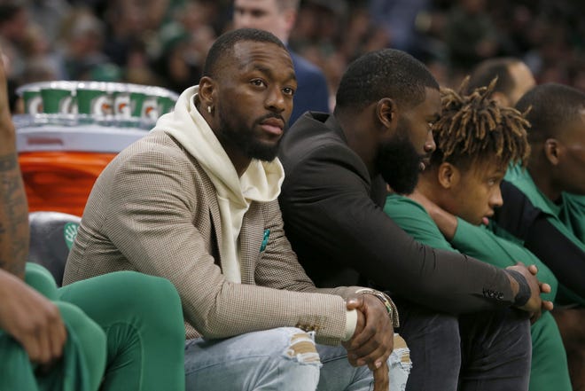 The Celtics' Kemba Walker and Jaylen Brown, from left, watch Saturday's game against the Suns from the bench. Both are questionable to play against the Lakers on Monday night. [AP / Mary Schwalm]