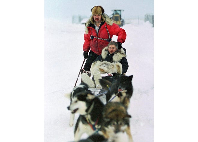 In this Jan. 19, 2000, file photo, U.S. Census Bureau director Kenneth Prewitt, seated, gets a dog sled ride into town by Harold Johnson after arriving for the first count in the Eskimo village of Unalakleet, Alaska. The 2020 Census kicks off Tuesday, Jan. 21, 2020, in remote Alaska. The first count in the Bering Sea community of Toksook Bay. The Census always starts in remote parts of the nation's largest state out of tradition and necessity. (AP Photo/Al Grillo, File)