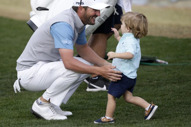 Andrew Landry, left, greets his son, Brooks, on Sunday after winning The American Express golf tournament on the Stadium Course at PGA West in La Quinta, Calif. [Alex Gallardo/The Associated Press]