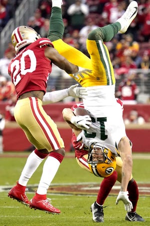 Green Bay Packers wide receiver Allen Lazard (13) falls to the ground between San Francisco 49ers free safety Jimmie Ward (20) and Emmanuel Moseley during the first half of the NFC Championship football game Sunday in Santa Clara, California. [Tony Avelar / Associated Press]