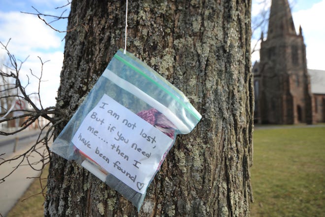 A bag filled with winter items and snacks hangs from a tree in front of St. Barnabas Episcopal Church on Main Street in Falmouth. Students in Heather Grey's Sunday school class created the bags, which are free for the taking. [Merrily Cassidy/Cape Cod Times]