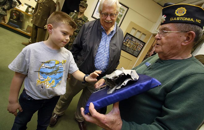 Eight-year-old Gunnar Erickson and his grandfather, Ted Erickson, check out a piece of a B-17 held by Jim Mayo during a tour of the American Military Museum on West Second Avenue in Gastonia Monday evening, Jan. 13, 2020. [Mike Hensdill/The Gaston Gazette]