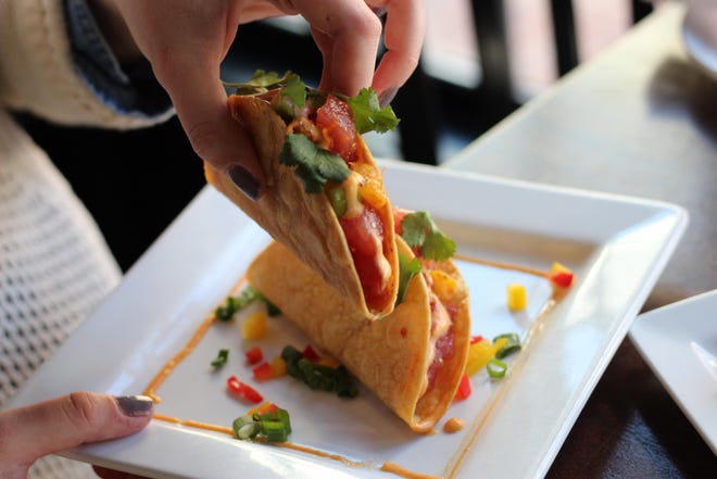 Daily News food writer Rachael Thatcher holds a tuna tartare taco at Midtown Oyster Bar in Newport. [ALEX COTTON PHOTO]