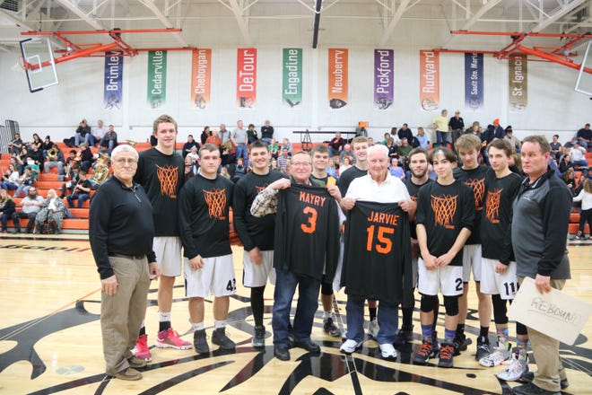 Willard Mayry (3) and Delbert Jarvie (15), who were members of the Rudyard basketball team of 1949-59, are pictured with current Rudyard players, coaches and administrators. [Courtesy of Stephanie Warner]