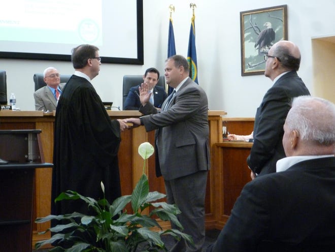 Judge Brian T. McGuffin of the Bucks County Court of Common Pleas swears in Assistant Bucks County Solicitor Keith Bidlingmaier at the county commissioners’ meeting Wednesday. Bidlingmaier is also chief of the Fairless Hills Fire Department. [PEG QUANN / STAFF PHOTOJOURNALIST]