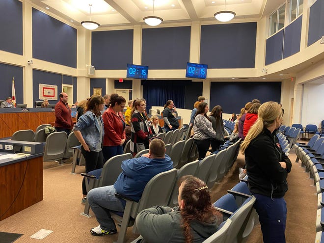 Students, teachers and parents stand and turn their backs on a speaker who’s challenging the need for policies and procedures to protect transgender and LGBTQ students during the public comment portion of Tuesday night’s Flagler County School Board meeting. [News-Journal/Aaron London]