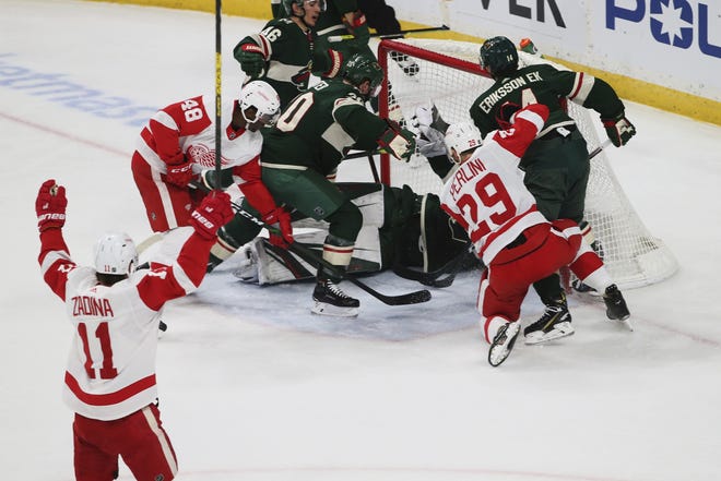 Detroit Red Wings' Filip Zadina, lower left, of Czech Republic, celebrates his power play goal off Minnesota Wild's Devan Dubnyk in the first period of an NHL hockey game Wednesday, Jan. 22, 2020, in St. Paul, Minn. It was Zadina's second goal of the period. (AP Photo/Jim Mone)