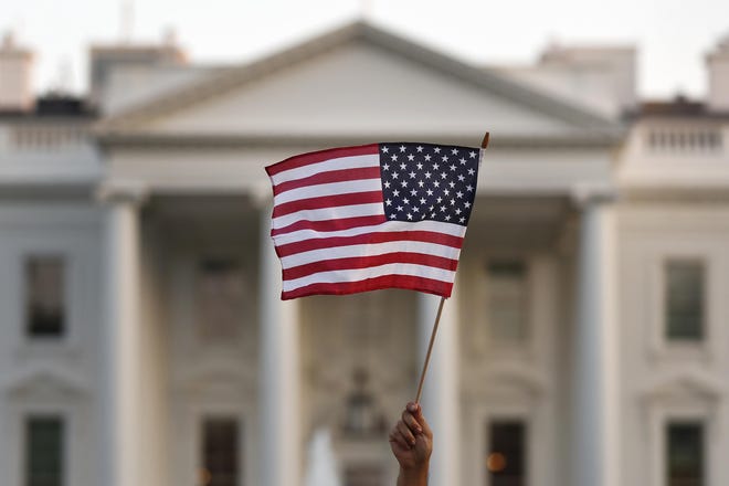FILE - In this Sept. 2017 file photo, a flag is waved outside the White House, in Washington. The Trump administration is coming out with new visa restrictions aimed at restricting a practice known as “birth tourism." That refers to cases when women travel to the United States to give birth so their children can have U.S. citizenship. (AP Photo/Carolyn Kaster)