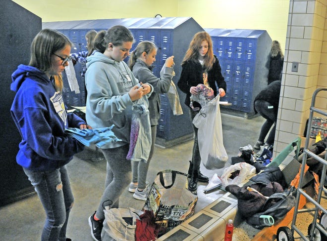 From left, Anne Liese, Kylie Sommers, Kaylee West and Schase Followay go through bags of clothes for sorting into sizes at the clothing closet at Edgewood Middle School.