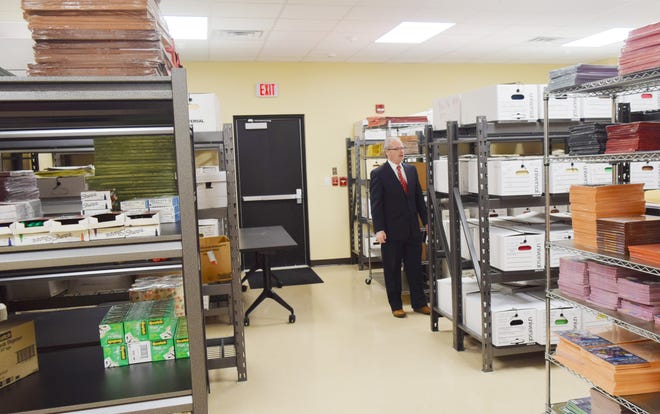 Kewanee School Supt. Dr. Chris Sullens looks over some of the records in a storeroom in the new addition to the school district’s administrative headquarters.[Mike Berry]