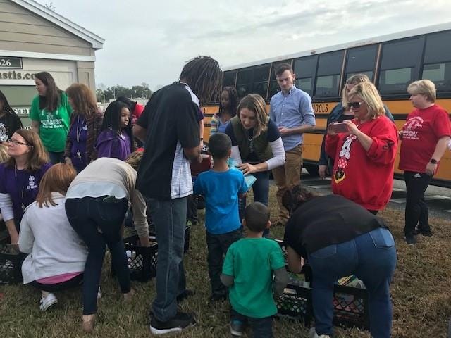 Teachers and administrators from Eustis Heights Elementary School took a bus ride through the city on Jan. 27, making stops along the way to greet students with free books. [SUBMITTED]