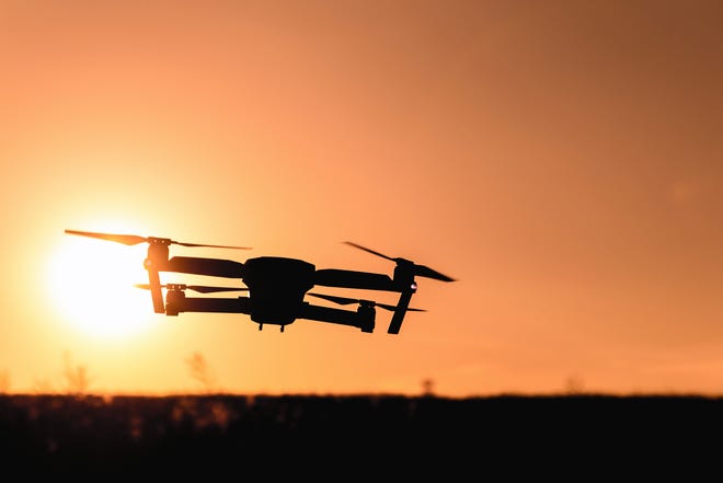 Drone silhouette with camera flying in the sunset light. [Pexels]