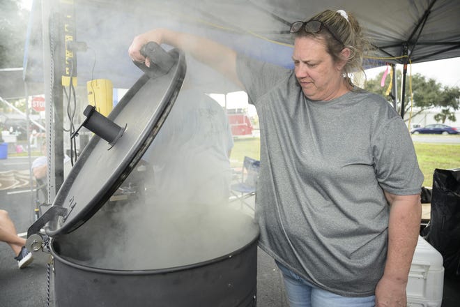 A woman checks to see if the smoker is ready at the 7th annual Chairty Chili Cook-off and BBQ Compeititon on Friday, Jan. 24, 2020. [Cindy Sharp/Correspondent]