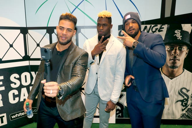 Chicago White Sox's Yoan Moncada, left, Luis Robert, center, and Jose Abreu pose for a video during the team's annual fan convention Friday, Jan. 24, 2020, in Chicago. (AP Photo/Charles Rex Arbogast)