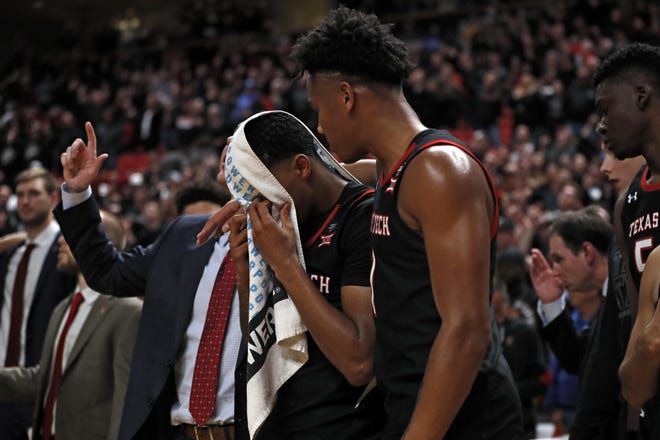 Kyler Edwards (0) covers his head with a towel after No. 18 Texas Tech dropped a 76-74 overtime decision to No. 18 Kentucky in a Big 12/SEC Challenge game Saturday at United Supermarkets Arena. [AP Photo/Brad Tollefson]