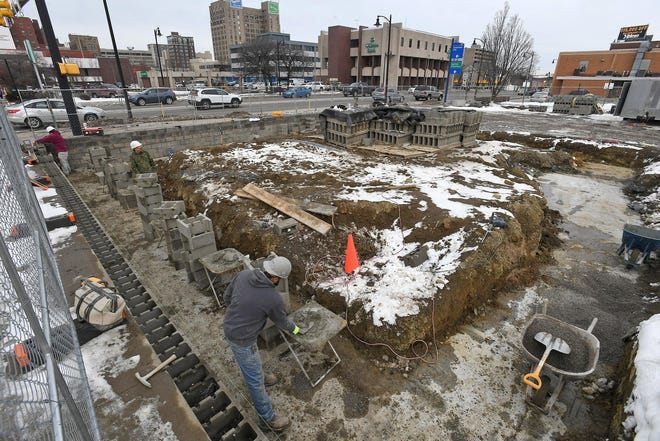 Workers with Ron Blondale Mason Contractor, of Millcreek Township, lay the foundation Thursday for a new bank building at 25 W. 12 St., on the southeast corner of Peach and West 12th streets in Erie, just north of the Union Square Townhouses. The city of Erie issued a building permit on Dec. 16, 2019 for the construction of a $750,000 2,484-square-foot bank building. The property is owned by Erie businessman Pete Zaphiris, who has extensive pans for redeveloping along West 12th Street. [CHRISTOPHER MILLETTE/ERIE TIMES-NEWS]