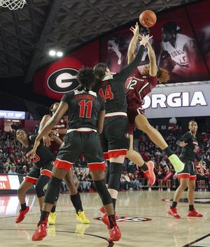 South Carolina Brea Beal (12) shoots over Georgia's Maya Caldwell (11) and Jenna Staiti (14) during the first half Sunday in Athens. [TAMI CHAPPELL/THE ASSOCIATED PRESS]