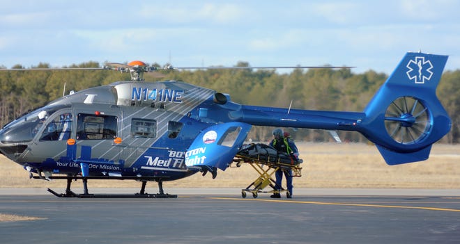 A woman who had been involved in a motorcycle crash is transferred from a Yarmouth Fire Department ambulance to a Boston MedFlight helicopter that landed at Barnstable Municipal Airport in Hyannis on Sunday afternoon. [Merrily Cassidy/Cape Cod Times]