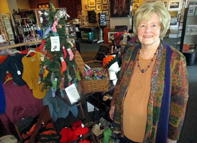 Rowena Krum poses Jan. 17 with some of her knitting, including miniature Christmas stockings, at Made In Chenango in Norwich. [MIKE JAQUAYS/MID-YORK-WEEKLY]