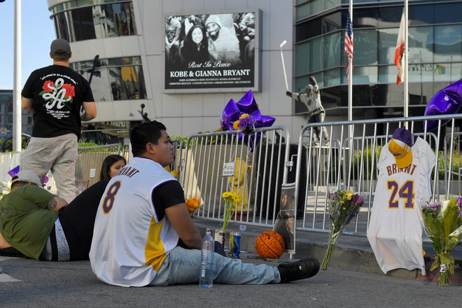 Fans gather in front of Staples Center where the Los Angeles Lakers play to memorialize Kobe Bryant Tuesday, Jan. 28, 2020, in Los Angeles following a helicopter crash that killed former NBA basketball player and his 13-year-old daughter, Gianna, and seven others. (AP Photo/Mark J. Terrill)