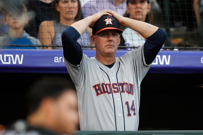 In this July 2, 2019, file photo, Houston Astros manager AJ Hinch reacts during a baseball game against the Colorado Rockies, in Denver. Hinch and general manager Jeff Luhnow were suspended for the entire season by MLB and fired by the Astros organization following the revelation of a cheating scandal earlier this month. [AP File Photo / David Zalubowski]