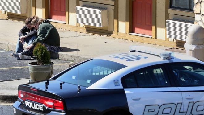 Two guests of the former Red Carpet Inn on Broadcast Street console one another as Gastonia Police respond in relation to the killing of a 29-year-old woman in a drug robbery. Two of those responsible for the incident have now been sentenced in federal court. [GAZETTE FILE PHOTO]