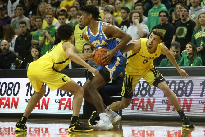 Oregon's Will Richardson (left) and Chris Duarte (5) pressure UCLA's Chris Smith during the first half of Sunday's game at Matthew Knight Arena. [Chris Pietsch/The Register-Guard] - registerguard.com
