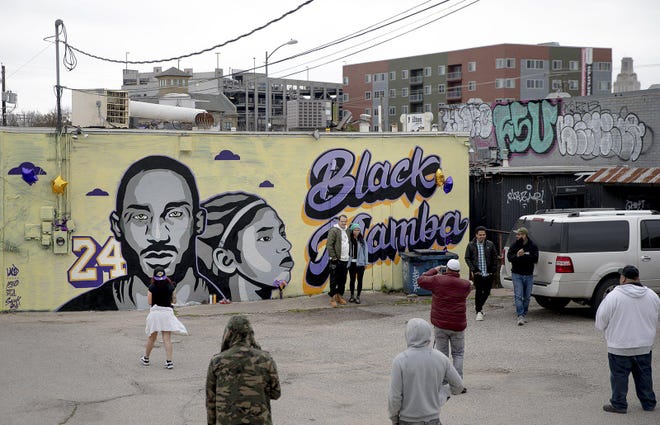 People take pictures Thursday of a new mural honoring Kobe Bryant and his daughter Gianna. The mural is located behind the Sushi Hi restaurant on Guadalupe Street. [NICK WAGNER/AMERICAN-STATESMAN]