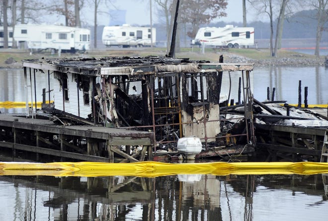 The charred remains of a boat are shown following a fatal fire at a Tennessee River marina in Scottsboro on Monday. Authorities said the boat believed to be where the fire originated was recovered Wednesday night. [Jay Reeves/The Associated Press]