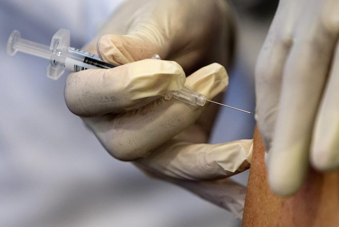 A nurse administers a flu vaccine shot. [AP FILE]