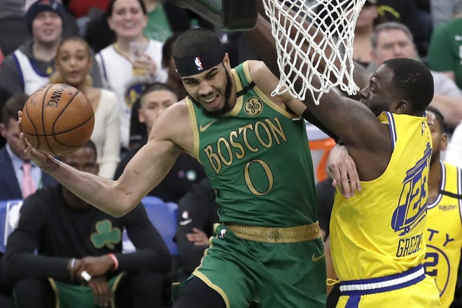 Boston Celtics forward Jayson Tatum (0) is defended by Golden State Warriors forward Draymond Green (23) during the first quarter of an NBA basketball game Thursday, Jan. 30, 2020, in Boston. (AP Photo/Elise Amendola)