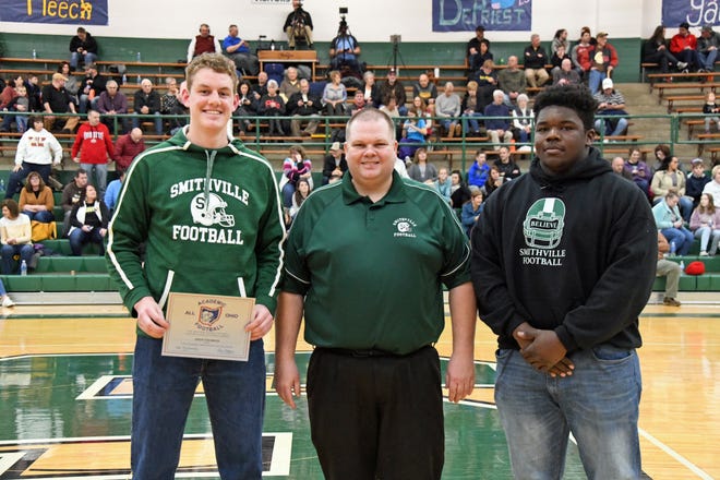 Two Smithville High School football players were honored at halftime of the Smithies' game with Waynedale on Friday. Simon Yochheim (left) earned Academic All-Ohio honors, which Smithies head football coach Mike Baker (center) presented to him. Meanwhile, Smithville honored Andrew Beery (right) for being the first Smithville player to be selected to the North-South All-Star Classic to be played in Massillon in April.