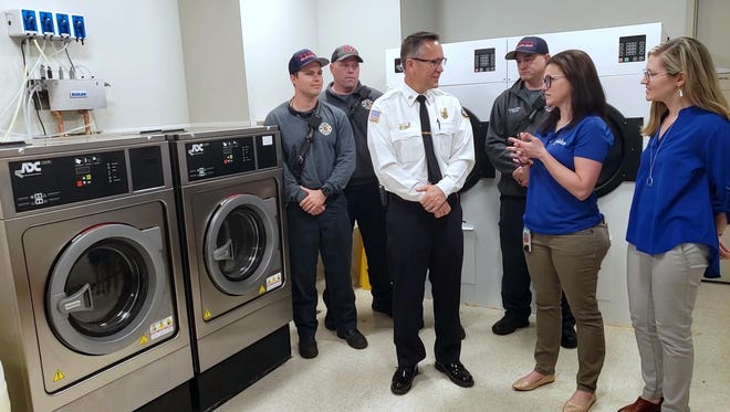 Laura Chorost, second from right, speaks with DeLand Fire Chief Todd Allen about why DaVita Labs donated two sets of industrial-grade washers and dryers to the fire department on Friday, Jan. 31, 2020. Chorost, who previously worked as a lieutenant with Volusia County fire, is the environmental, health and safety administrator at DaVita Labs in DeLand. [News-Journal/Katie Kustura]