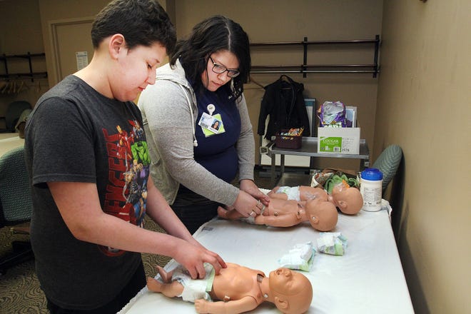 Brittany Wolf, right, instructs Cortez Zuniga how to put a diaper on an infant mannequin during a Safe Sitter class held Saturday, Feb. 1, 2020, at FHN Memorial Hospital in Freeport. [JANE LETHLEAN/THE JOURNAL-STANDARD CORRESPONDENT]