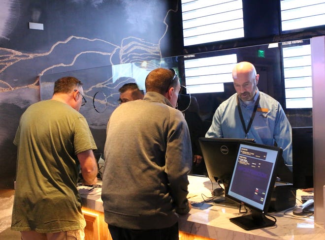 Tiverton Casino Hotel tellers help guests place their bets at the sports betting window in December, when the facility first started taking bets on sporting games. [DAILY NEWS FILE PHOTO]