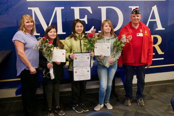 The three middle school winners were given their awards in the school’s Media Center. Pictured, from left, teacher Cyndie McDonough, winners Rylee Giles, Meilani Nguyen and Jadyn Paddack. Herald Keesee, of VFW Post 5551, presented the awards. [PETER DAY FOR THE DAILY PRESS]