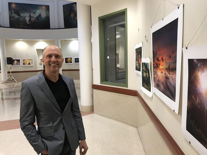 Fine art photographer Kirk Marsh is surrounded by his surreal images in the rotunda of the St. Johns County Administration Building. His work is thought-provoking, startling and often humorous. [SHAUN RYAN/THE RECORD]