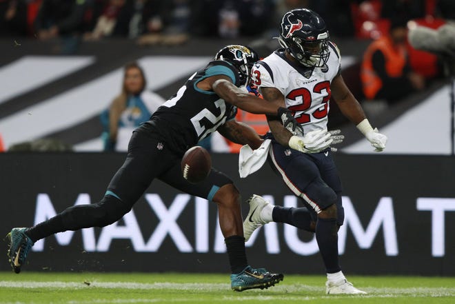 Houston Texans running back Carlos Hyde (23) loses the ball against Jacksonville Jaguars free safety Jarrod Wilson (26) during the second half of an NFL football game at Wembley Stadium, Sunday, Nov. 3, 2019, in London. (AP Photo/Ian Walton)